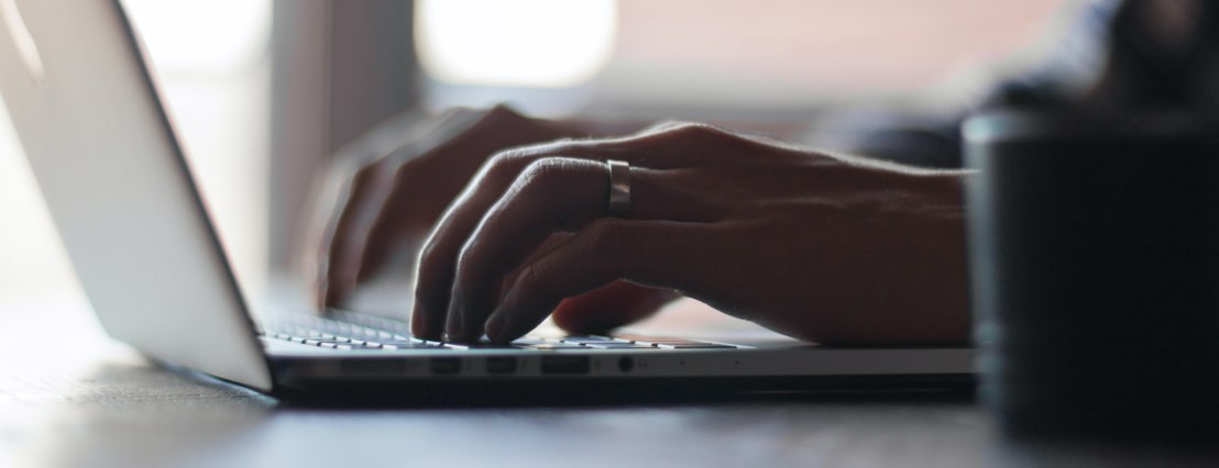 A man typing on an Apple Mac computer